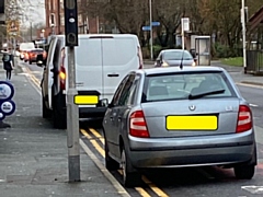 Two of the vehicles parked on double yellow lines on Whitworth Road
