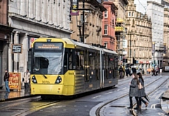 A Metrolink tram to Rochdale via Exchange Square, pictured on Cross Street, Manchester city centre